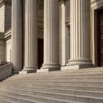 The stone steps and columns of a London courthouse representing the judicial review process in immigration cases