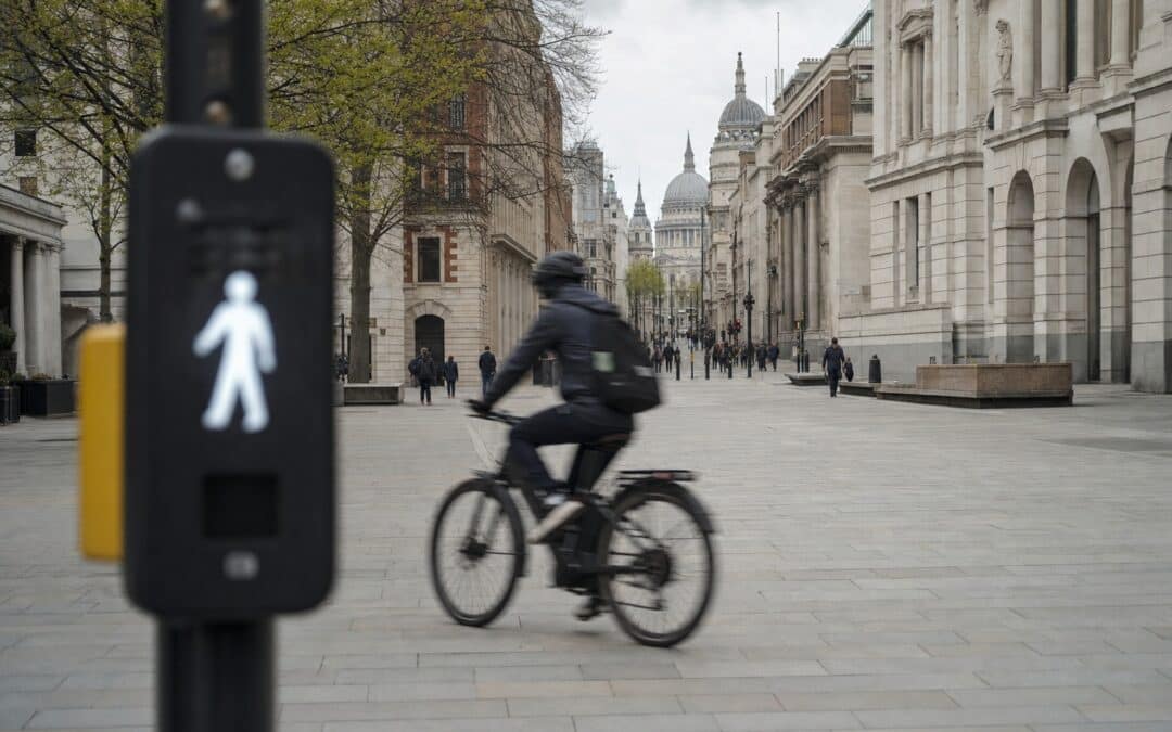 Cyclist riding an e-bike through a pedestrianised London street