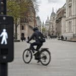 Cyclist riding an e-bike through a pedestrianised London street